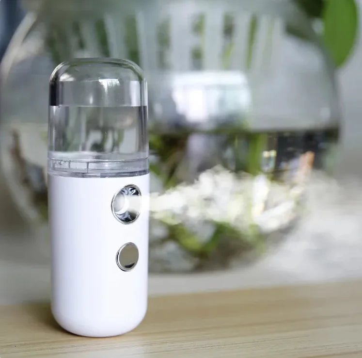 White and clear facial steamer on a wooden surface with a blurred background